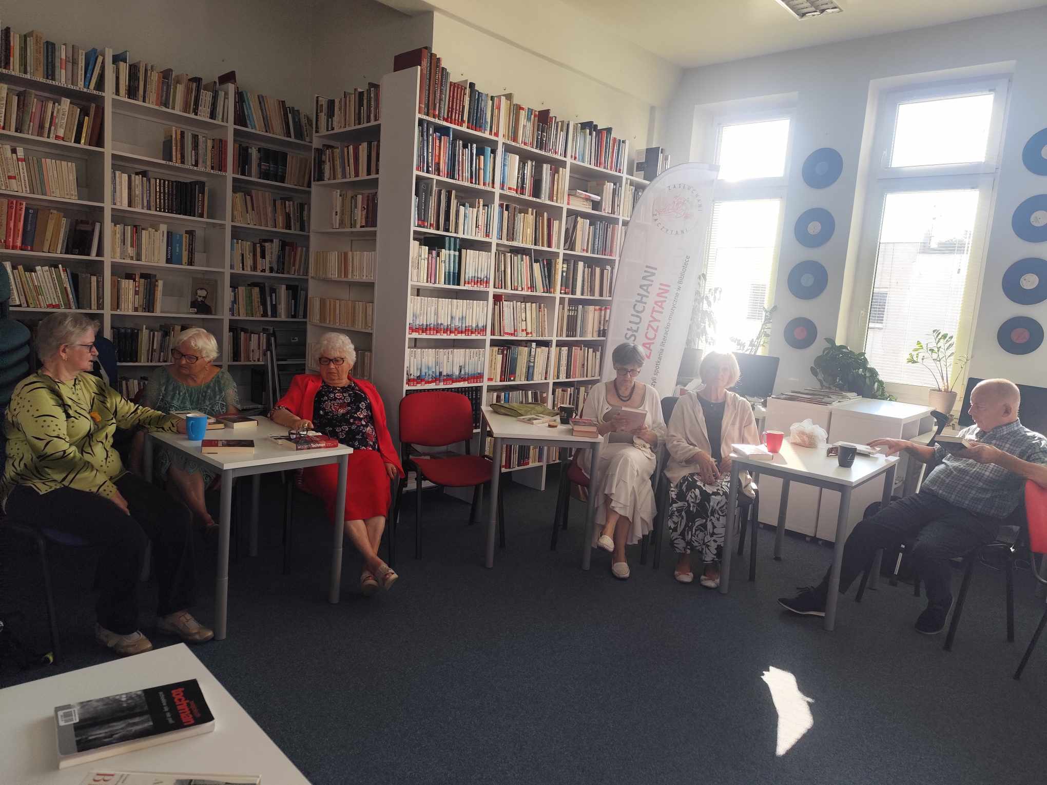Zdjęcie przedstawia ludzi w bibliotece