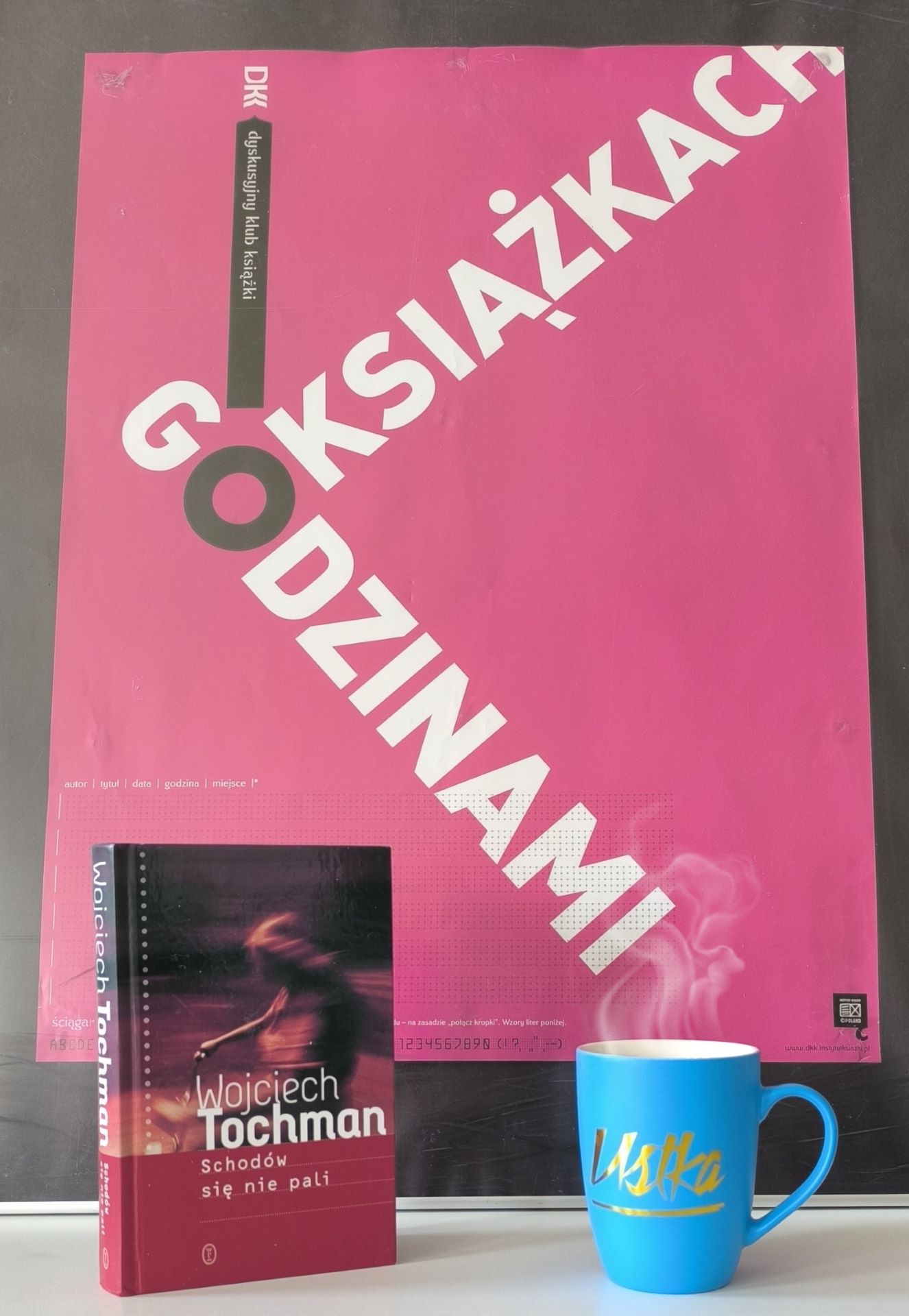 Zdjęcie przedstawia książkę i plakat