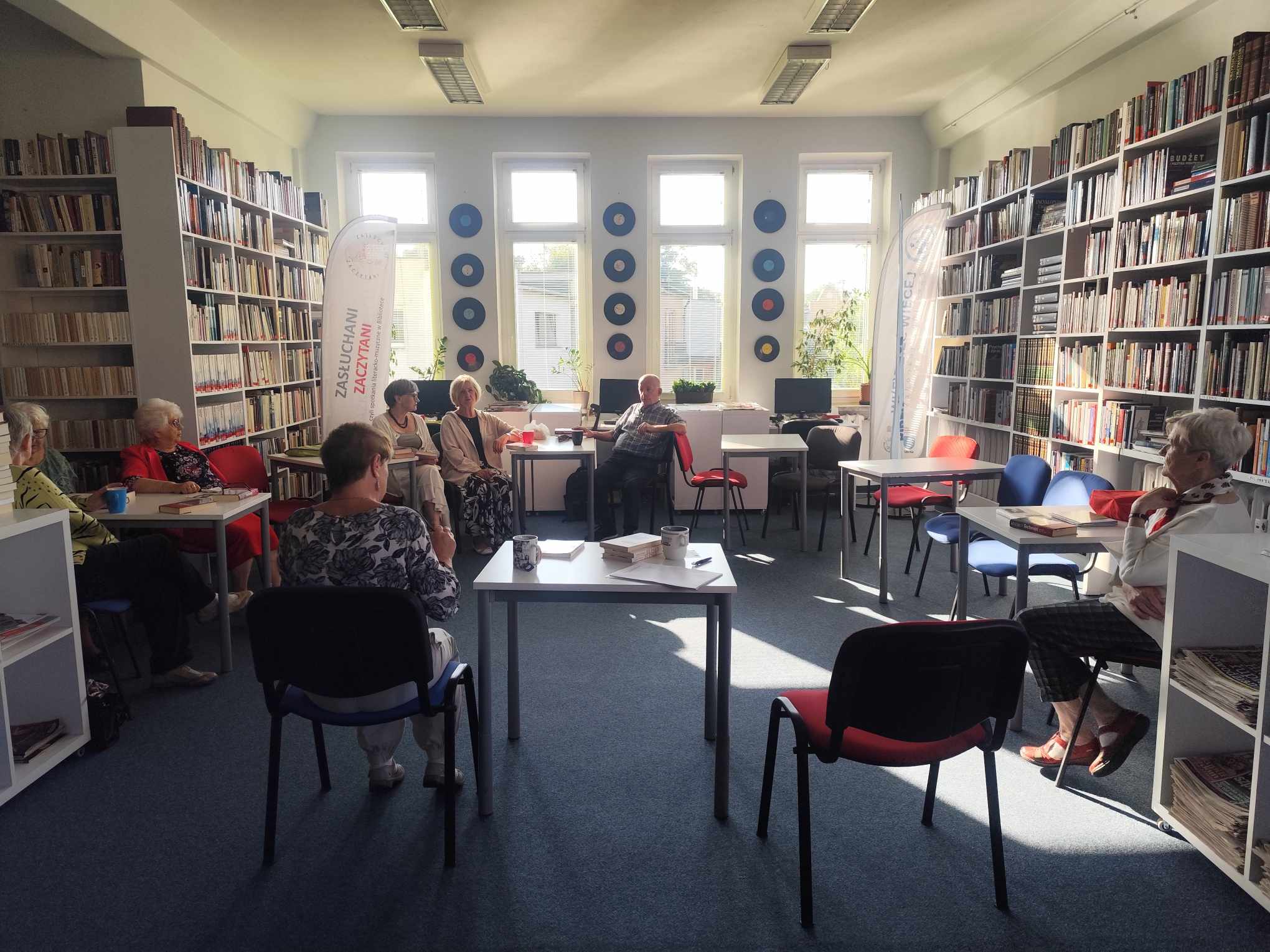 Zdjęcie przedstawia ludzi w bibliotece