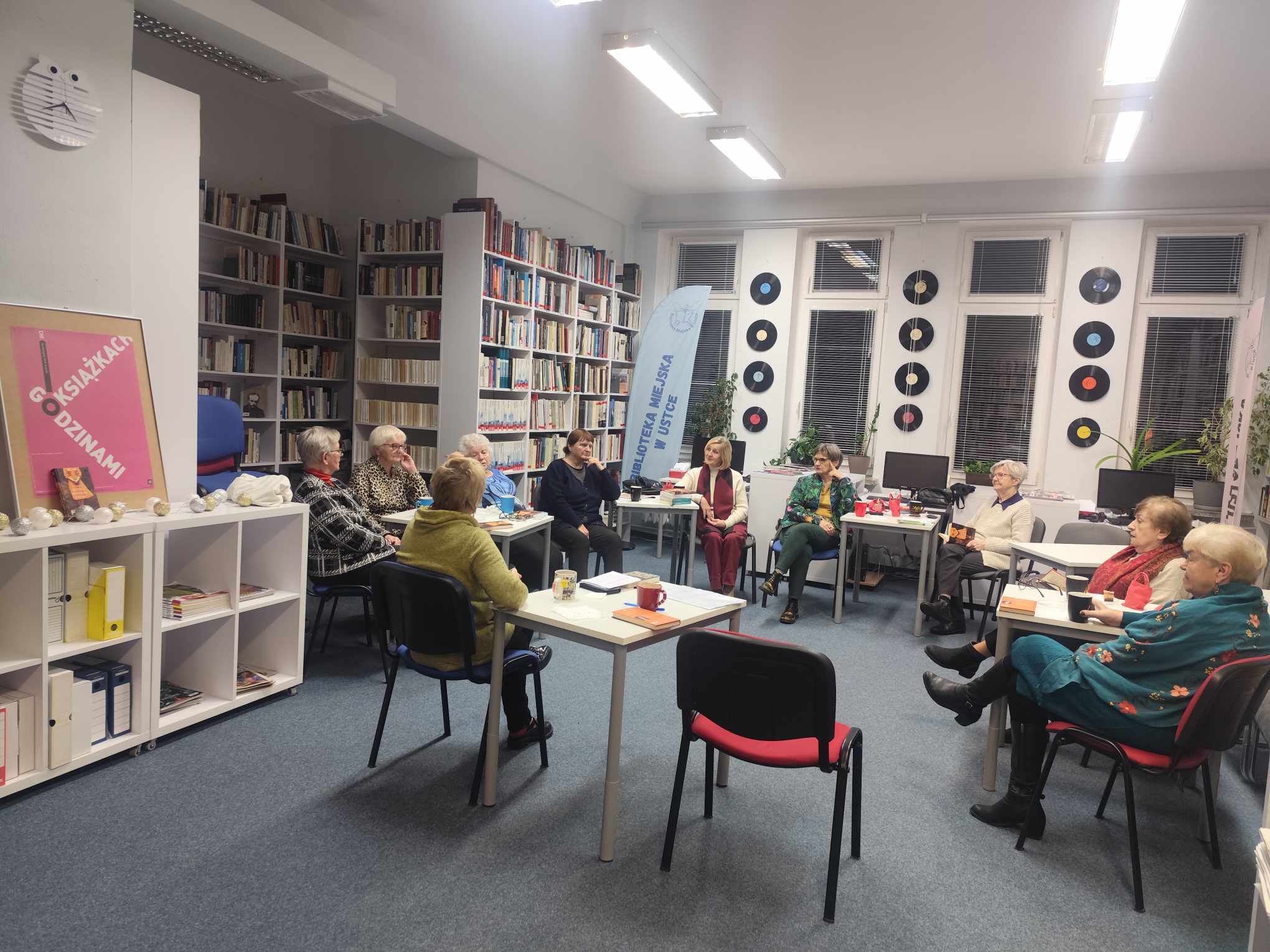 Zdjęcie przedstawia ludzi w bibliotece