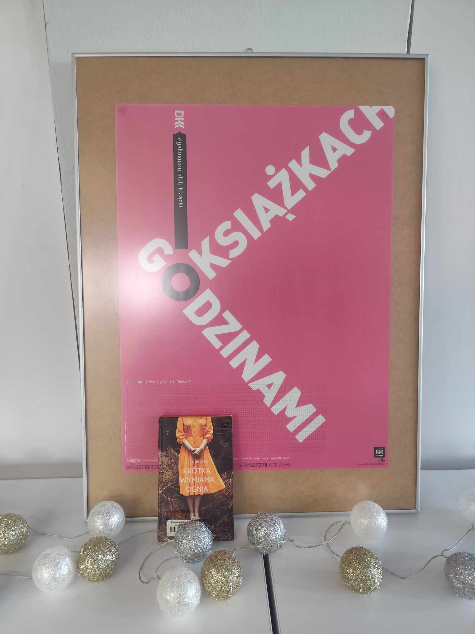 Zdjęcie przedstawia książkę i plakat