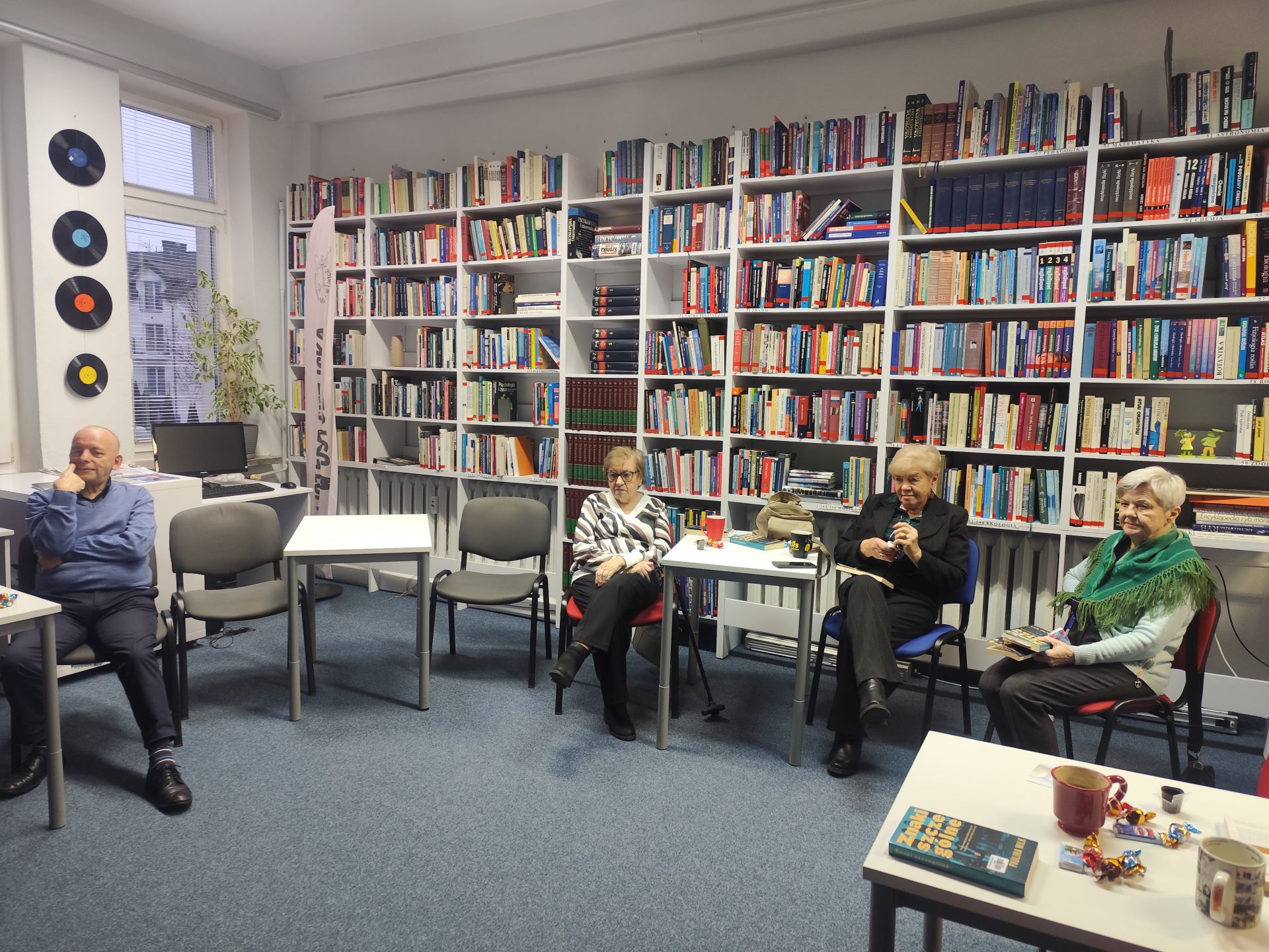 Zdjęcie przedstawia ludzi w bibliotece