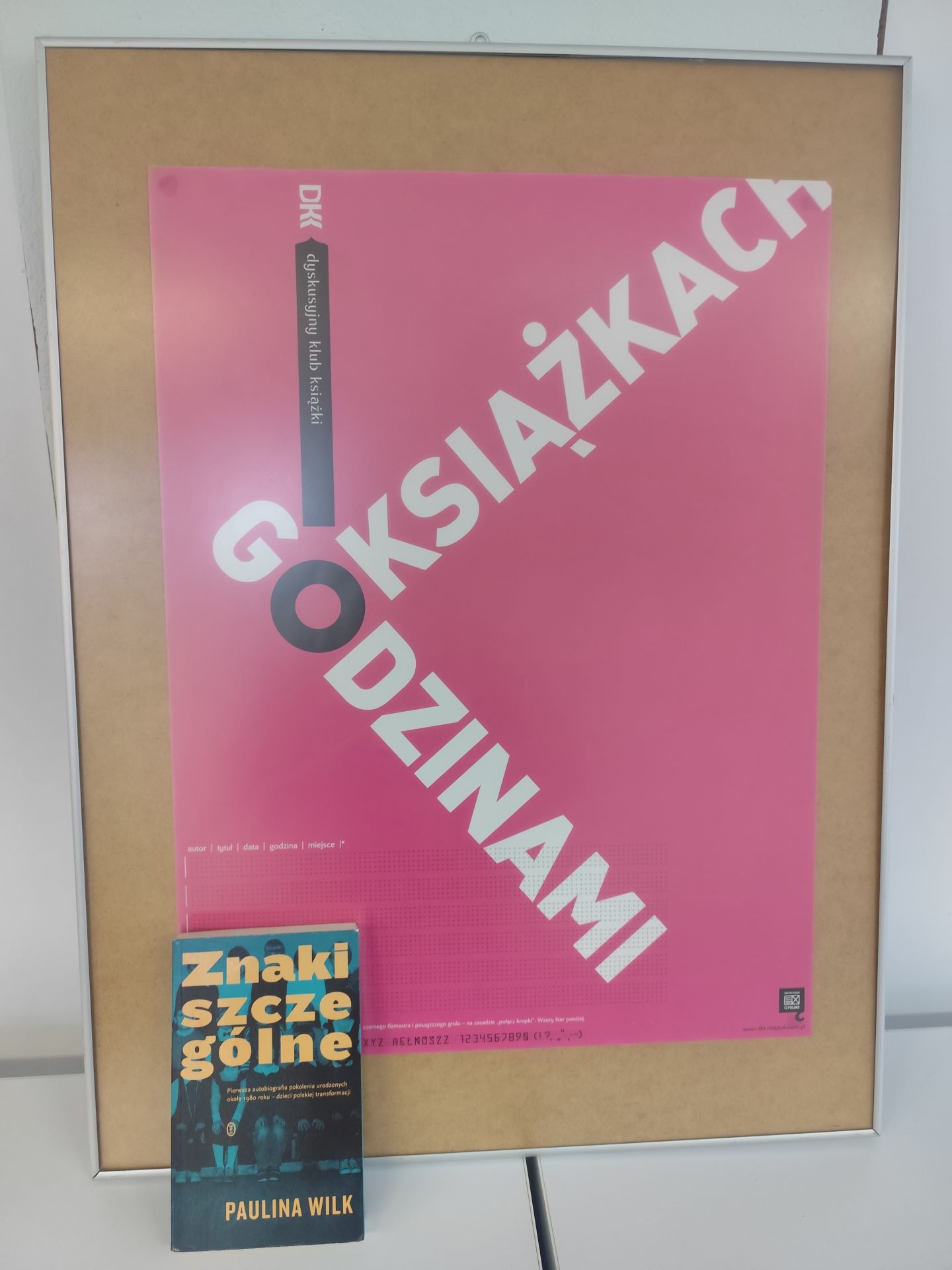 Zdjęcie przedstawia książkę i plakat