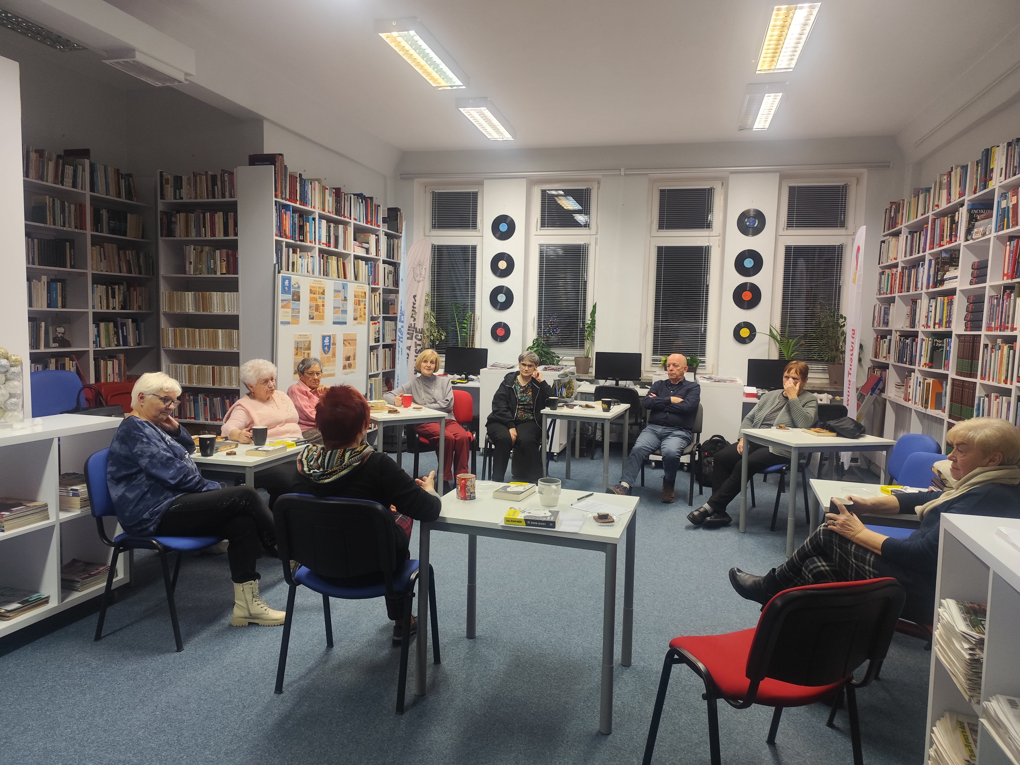 Zdjęcie przedstawia ludzi w bibliotece