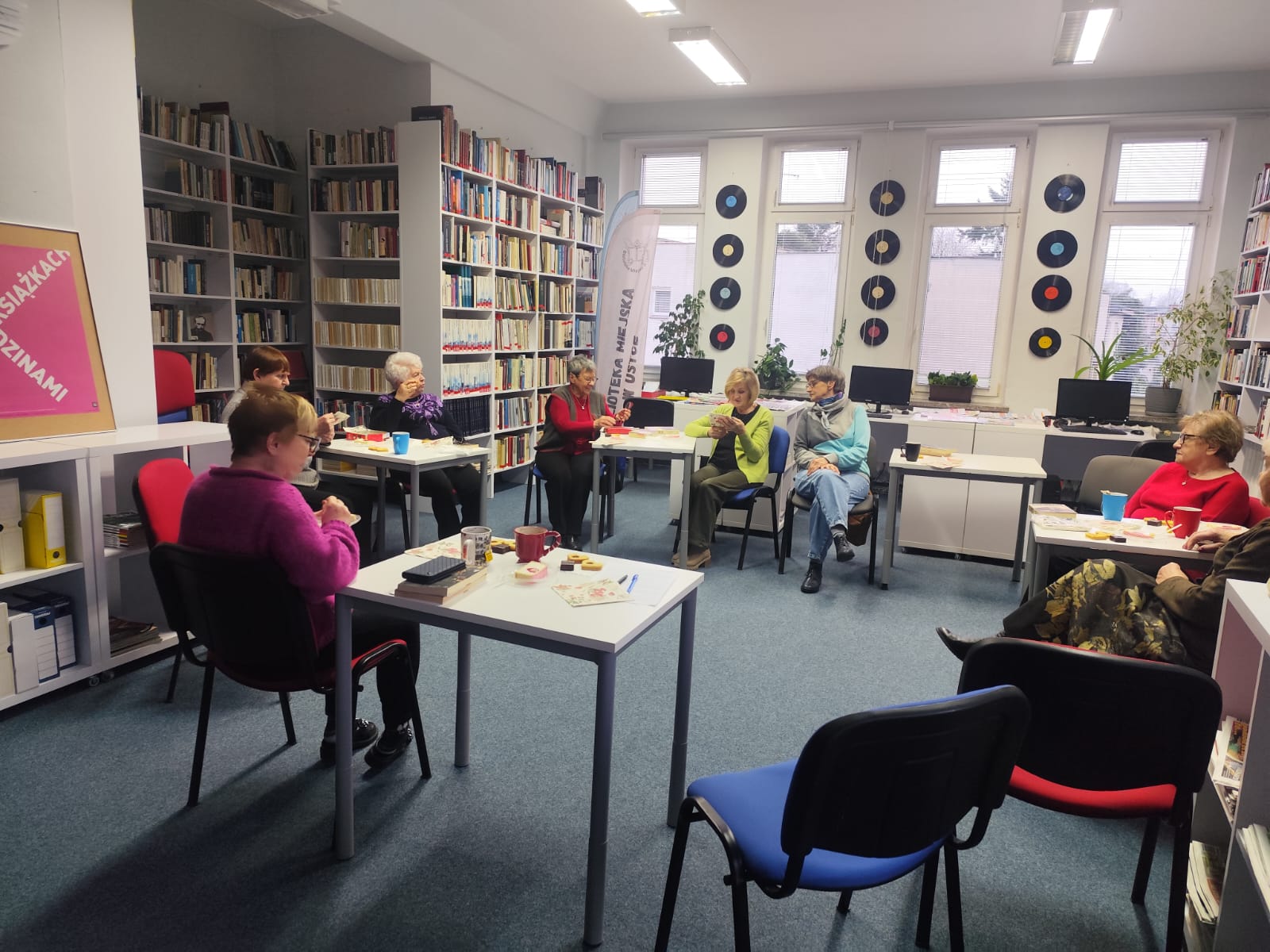 Zdjęcie przedstawia ludzi w bibliotece