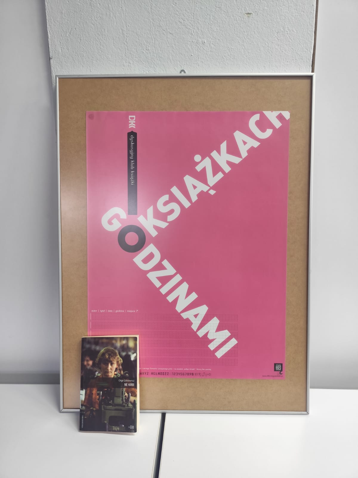 Zdjęcie przedstawia książkę i plakat