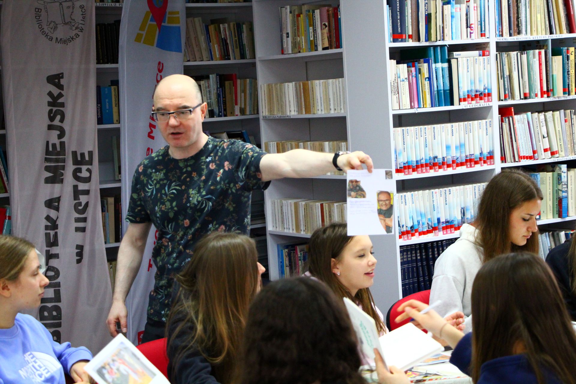 Zdjęcie przedstawia ludzi w bibliotece