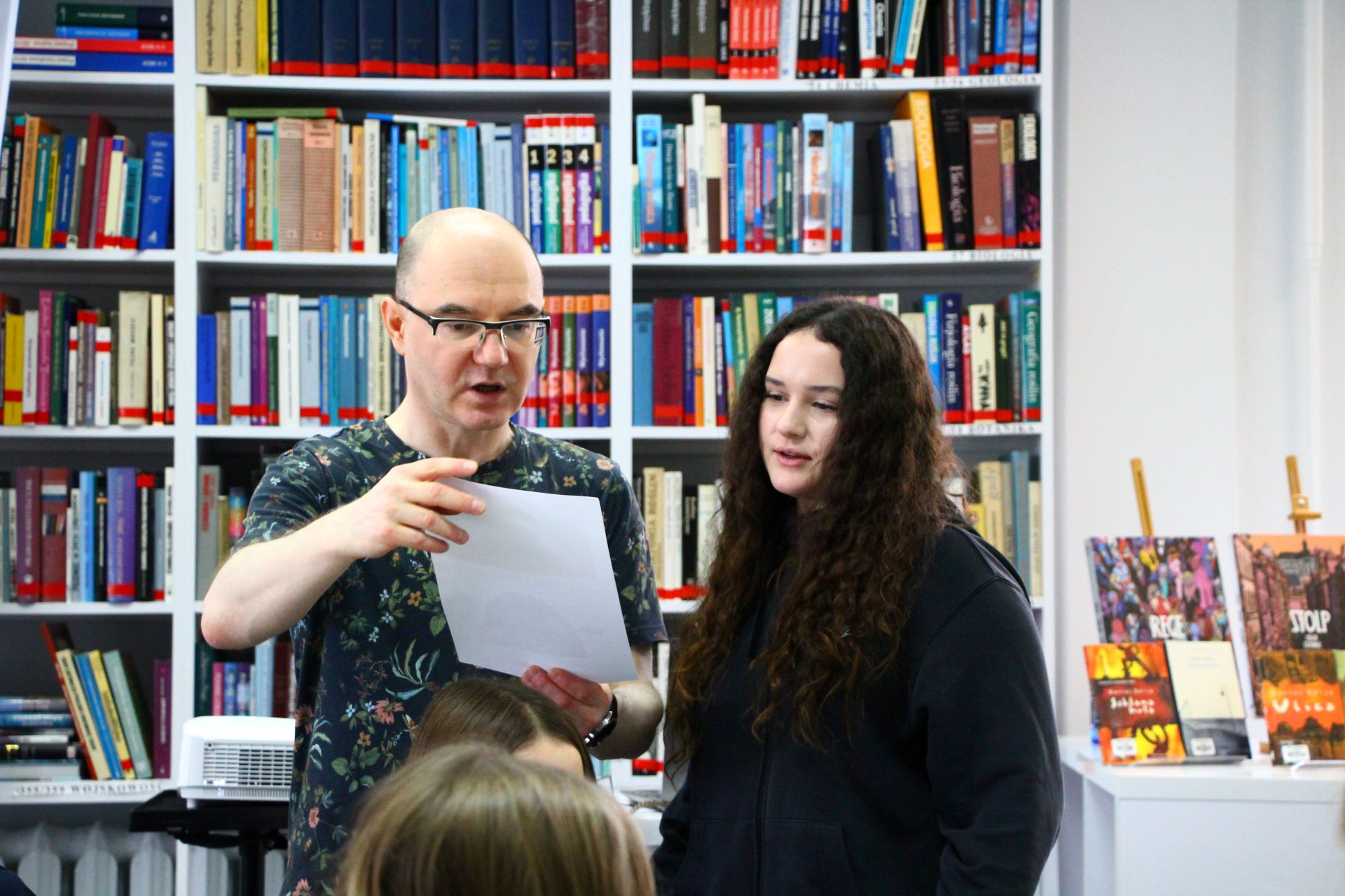 Zdjęcie przedstawia ludzi w bibliotece