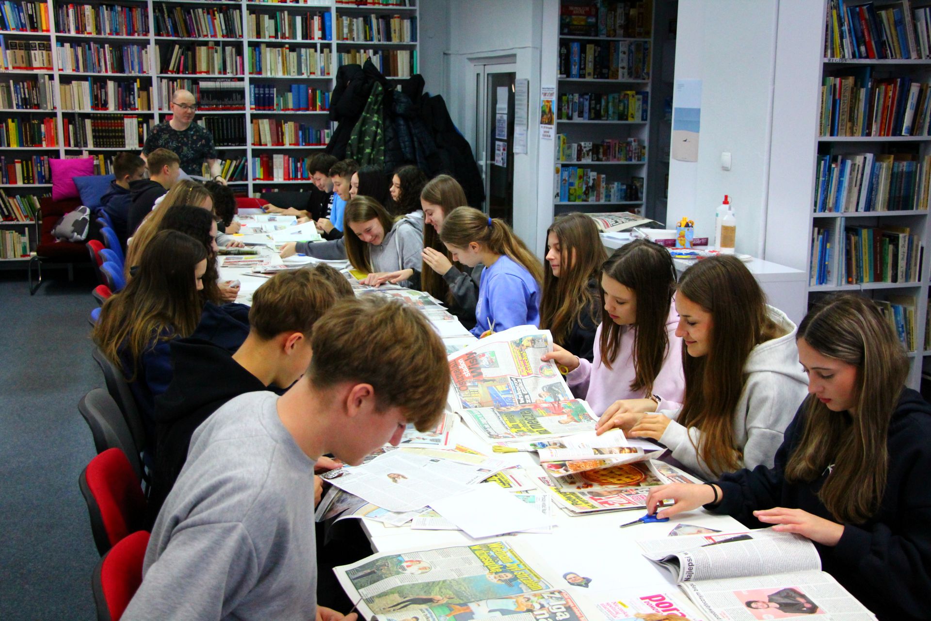 Zdjęcie przedstawia ludzi w bibliotece