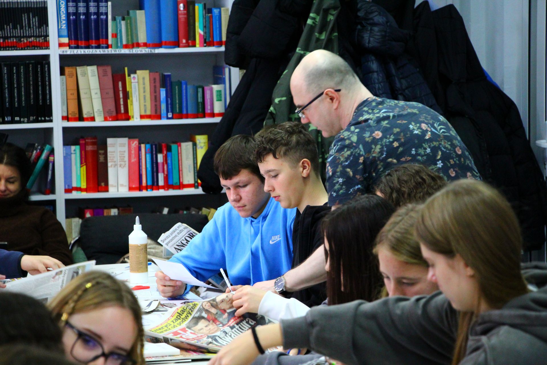 Zdjęcie przedstawia ludzi w bibliotece