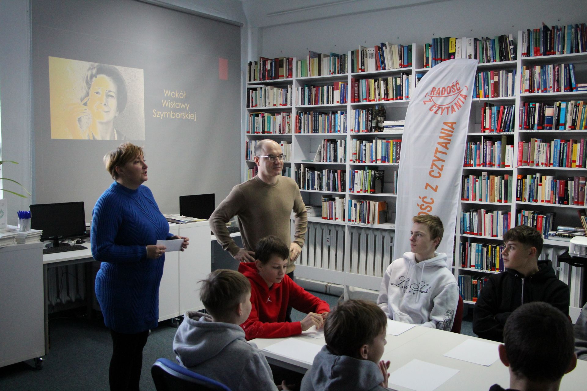 Zdjęcie przedstawia ludzi w bibliotece