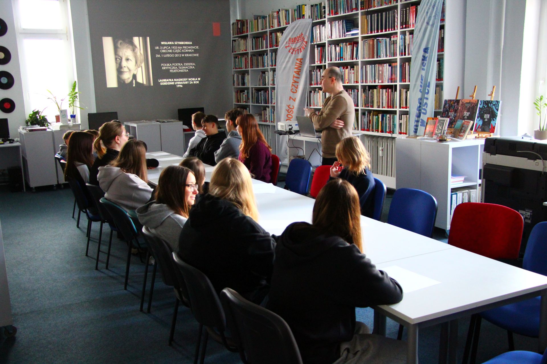Zdjęcie przedstawia ludzi w bibliotece