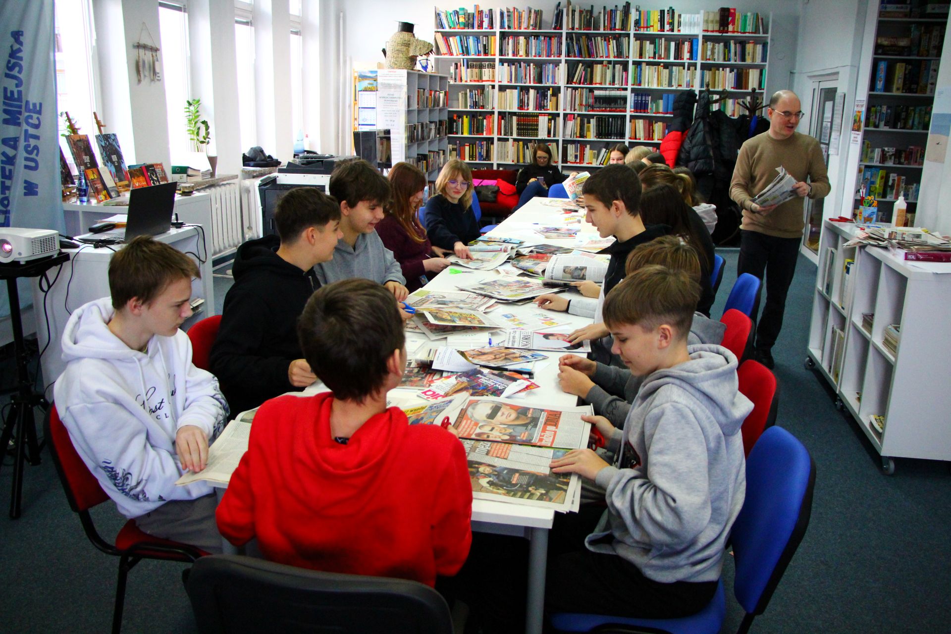 Zdjęcie przedstawia ludzi w bibliotece