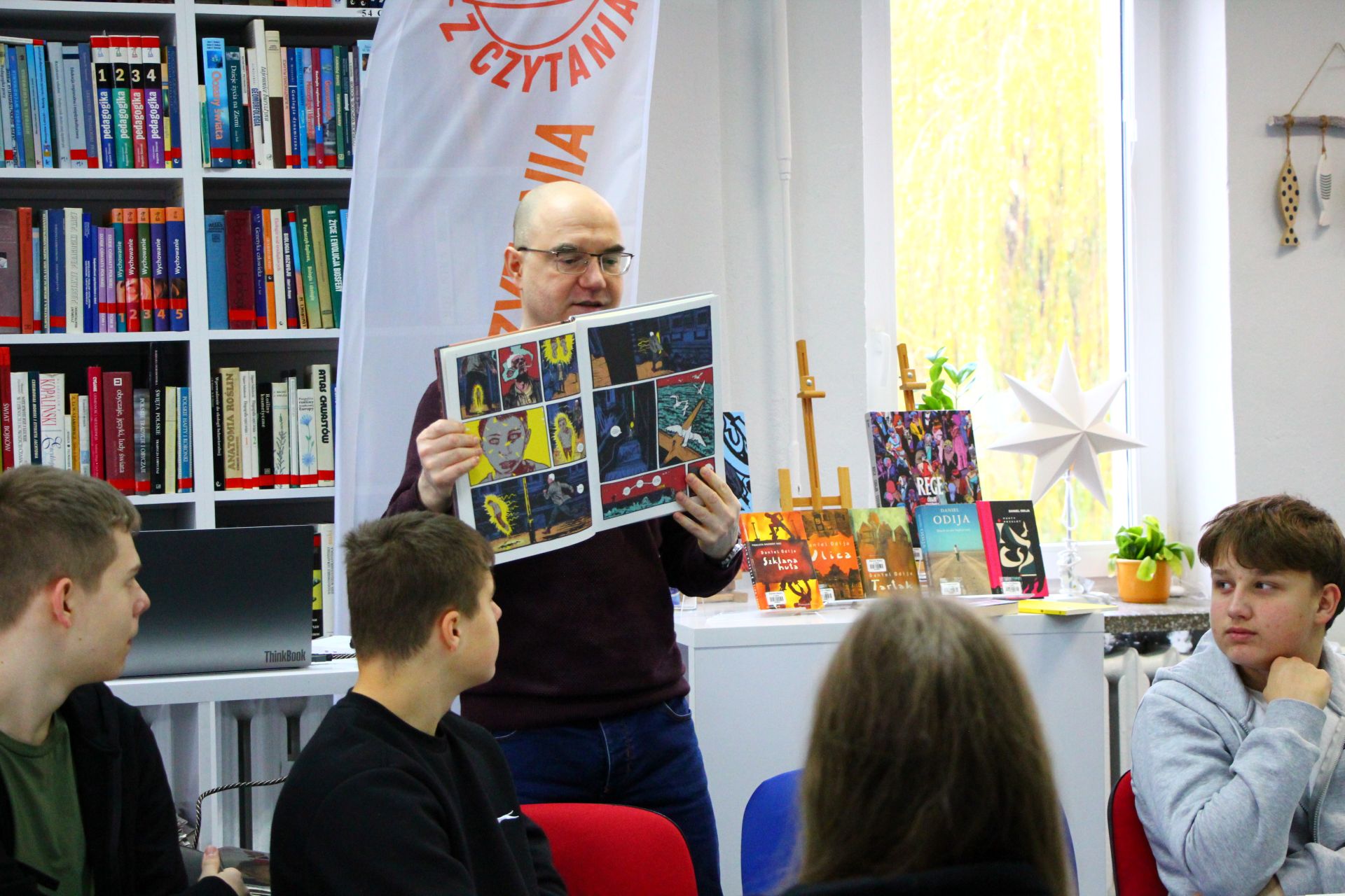Zdjęcie przedstawia ludzi w bibliotece