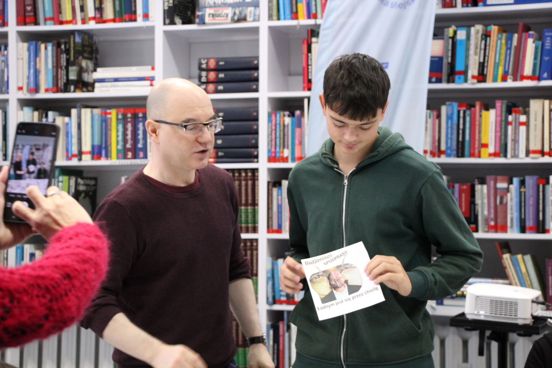 Zdjęcie przedstawia ludzi w bibliotece