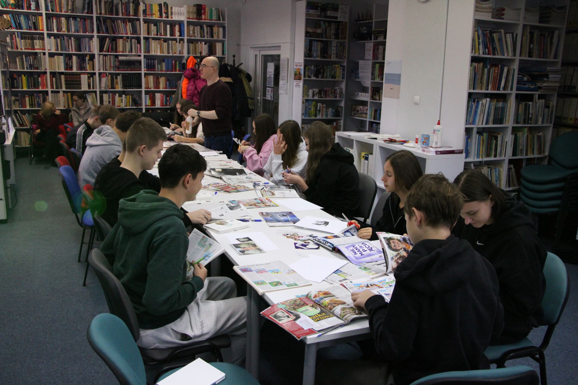 Zdjęcie przedstawia ludzi w bibliotece