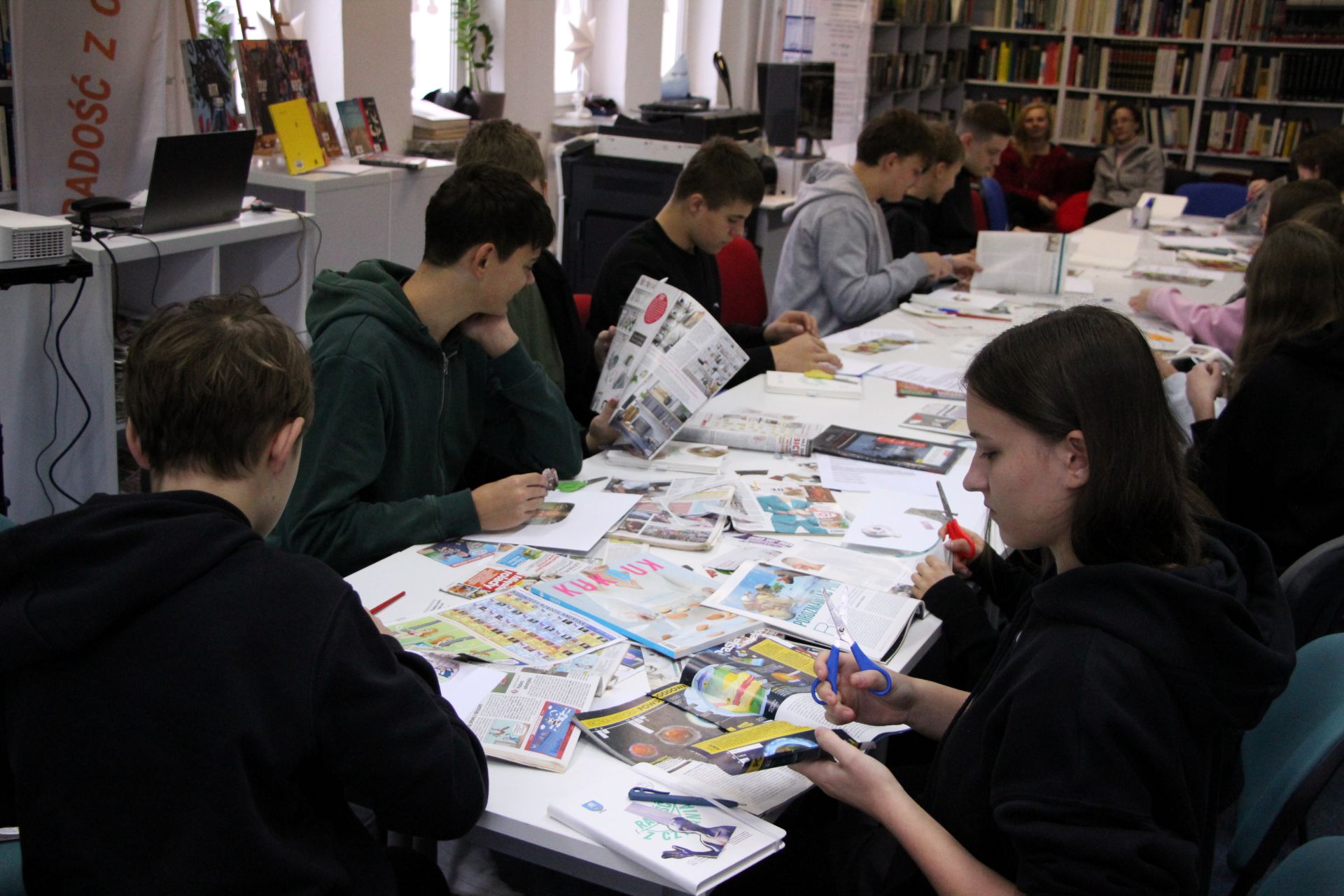 Zdjęcie przedstawia ludzi w bibliotece